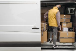 Bezorger laadt pakketten in bestelbus voor spoedlevering woning